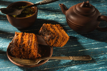 Still life with a piece of cake and morning tea - a delicious breakfast on a dark backgroundの写真素材