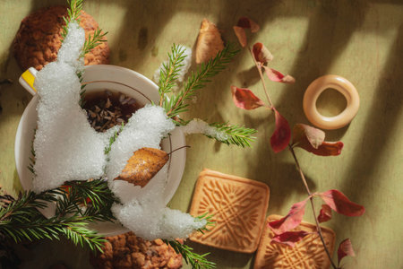 Cup of hot tea with cookies and christmas decoration on wooden background