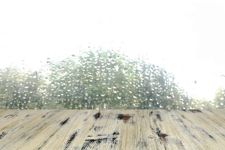 Empty washed wood table top ready for your product display montage. with rain drop on window backgroundの写真素材