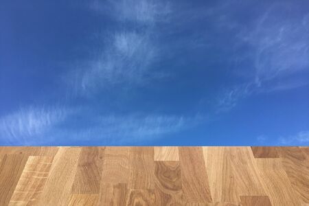light brown wooden planks as a wood table or parquet floor in perspective, isolated on blue sky or white cloudsの写真素材