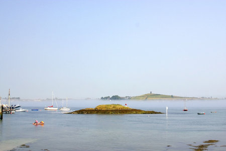 Island at a town of Ireland, with lighthouse and ships navigating