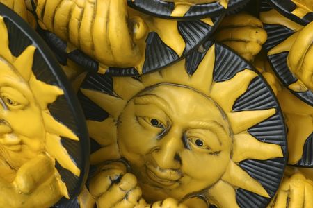 Heap of wooden yellow suns with face, nose, eyes and mouthの写真素材