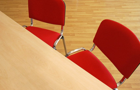 Office with furniture, wooden table, red chairs and ground of platform