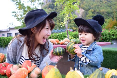 halloween mother and son with colorful pumpkinの写真素材