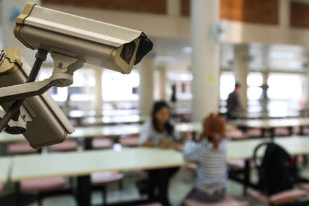 CCTV monitoring against blur of people at canteen or food court background, security cameras.の写真素材