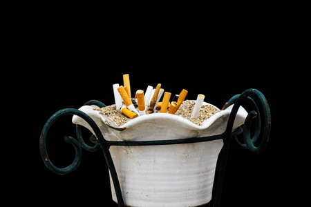 Ashtray ceramic and cigarette butts isolated on black background with clipping path.の写真素材