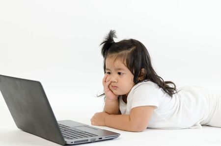 Asian child playing on computer laptopの写真素材
