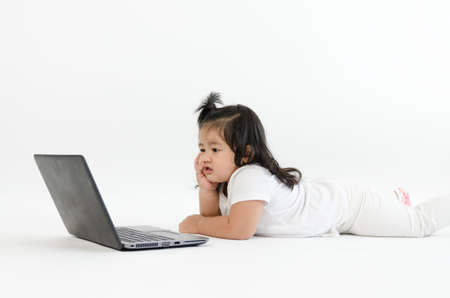Asian child playing on computer laptopの写真素材