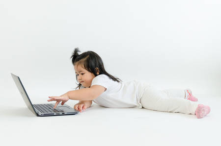 Asian child playing on computer laptopの写真素材