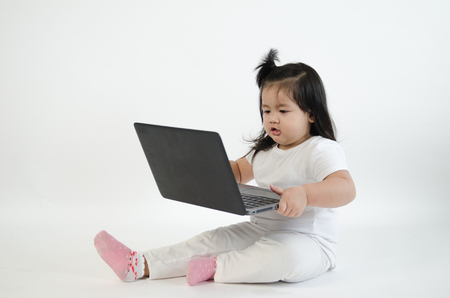 Asian child playing on computer laptopの写真素材