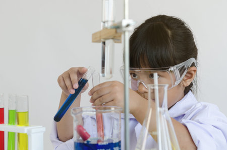 Asian children girl testing chemical in laboratory.