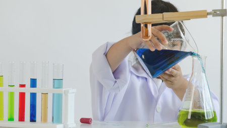 Asian children girl testing chemical in laboratory.