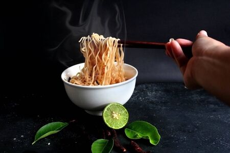Spicy hot noodles placed on a black background.の写真素材