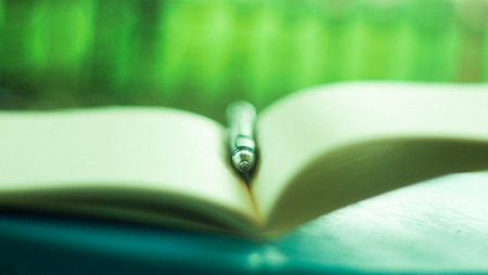 Close-up of open book and penの写真素材