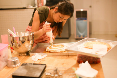 A young women is making homemade cake in the kitchen.