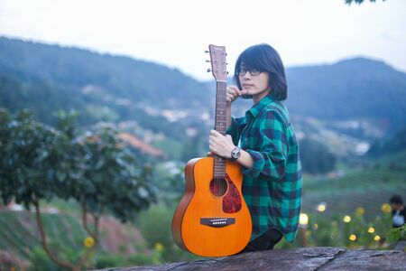 behind of a young girl with a guitar on the viewpoint , hipsterの写真素材