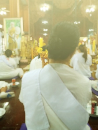 Women are worshiping buddha statue on Dharma in temples. To purify the mind and prepare for the Dharma on the day of the Buddha, Activities on Buddhist Monks Day, blurred photoの写真素材