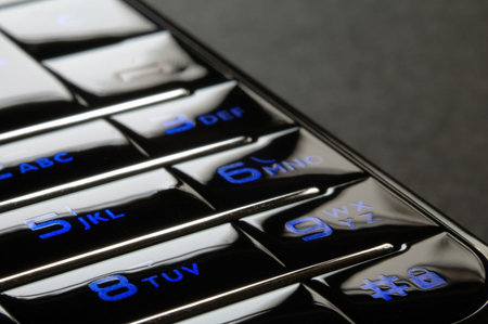 Close up shot of blue mobile keypad under dark environmentの写真素材