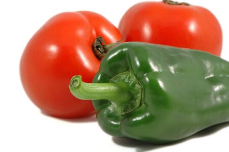 Green paprica and red tomatoes over whiteの写真素材