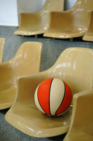 Line of stadium chairs with a basketballの写真素材