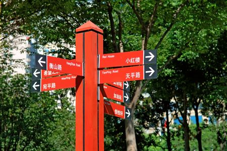 Multiple way red signpost in city parkの写真素材