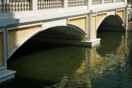 The arched support of stone birdge with reflection over waterの写真素材