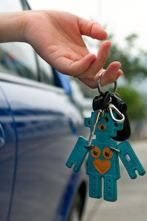 Hand holding the car key with lovely key ringの写真素材