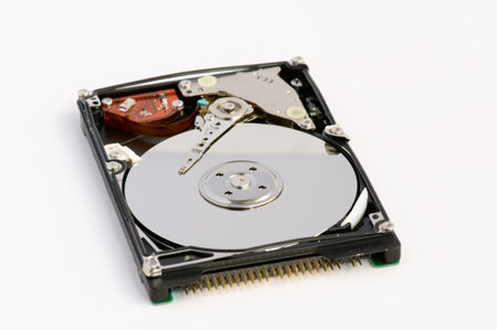 Opened hard disk showing the disk surface and drive head