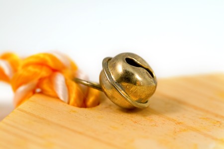 Closeup of decorative bronze bell on orange ropeの写真素材