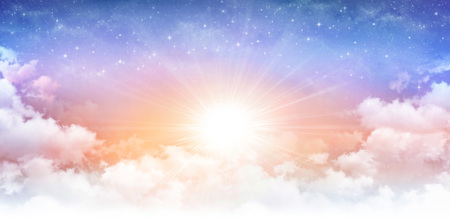 Heavenly sky, sun breaking through white clouds and stars shining behind.の写真素材
