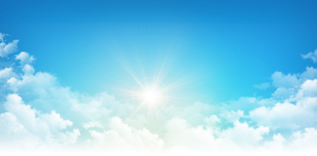 Sunlight breaking through white clouds in early morning blue skyの写真素材