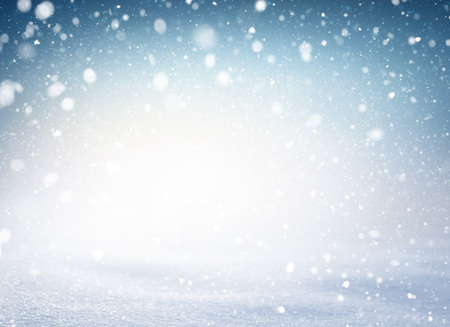 Snowflakes and snowfall exploding on a white snow covered ground and blue iced background. Winter seasonal material.の写真素材