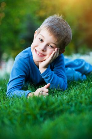 cheerful little kid laying on the grassの写真素材