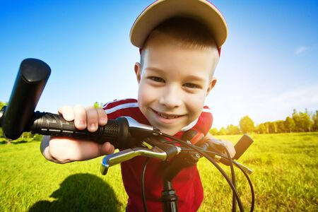Six  year old boy on a bike on a beautiful meadow covered in  flowersの写真素材