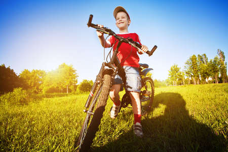 Six  year old boy on a bike on a beautiful sunny meadowの写真素材