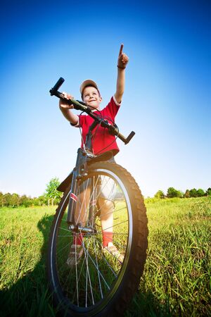 Six  year old boy on a bike on a beautiful meadow covered in  flowersの写真素材