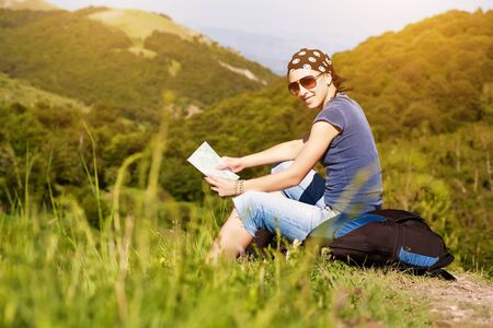 tourism. young girl is guided on the map in the mountainsの写真素材