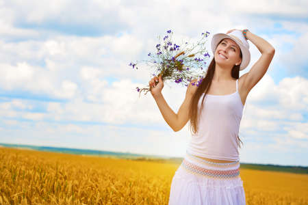 attractive girl s portrait  with wild flowers in the wheat fieldの写真素材