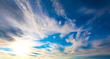Blue sky with clouds and sun の写真素材