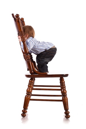 baby on a big wooden chair in a studio  isolatedの写真素材