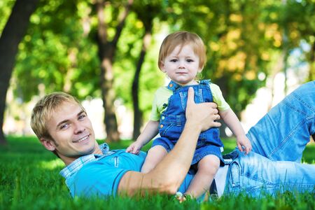 happy daddy with  baby in a greenl summer parkの写真素材