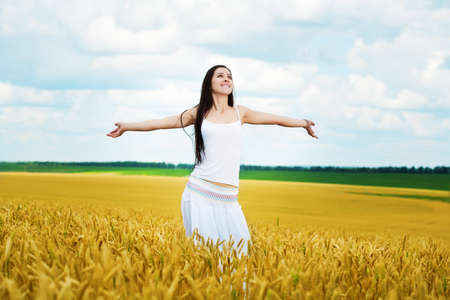 cute women walking in wheat fieldの写真素材