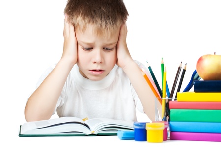 sad schoolboy doing is homeworkの写真素材
