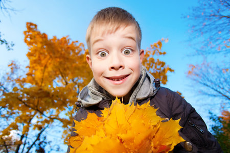 boy on a background of sky and autumn trees