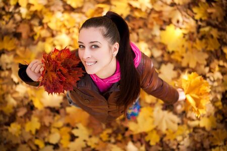 pretty girl on a background of  autumn leafs  top viewの写真素材