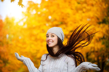 happy cheerful girl on a background of autumn treesの写真素材