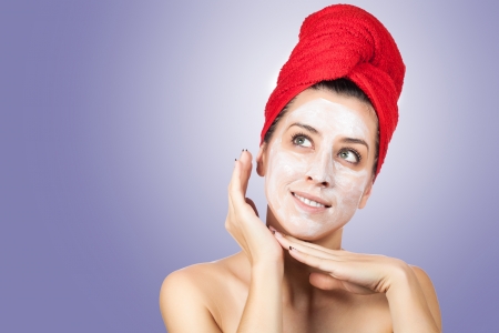 woman in towel with facial mask over blue backgroundの写真素材