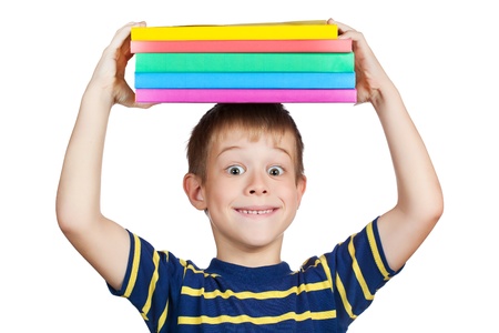 cute boy with a stack of books on his headの写真素材