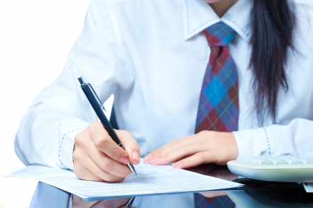 girl at work in the office  sign documentsの写真素材