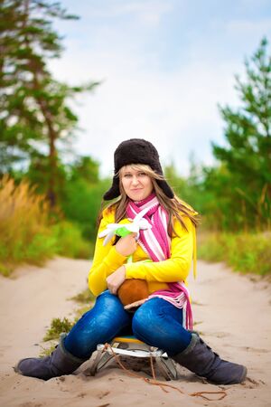 Funny girl in cap with ear flaps and flowerの写真素材